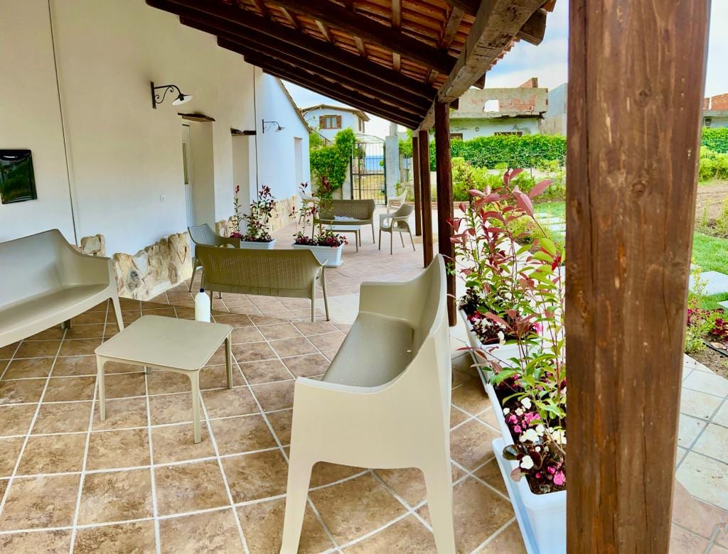 Terrazza coperta con tavoli e sedie affacciata sul giardino